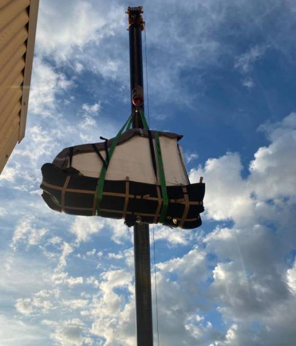 grua elevando un piano para ser instalado en un piso de alta altura