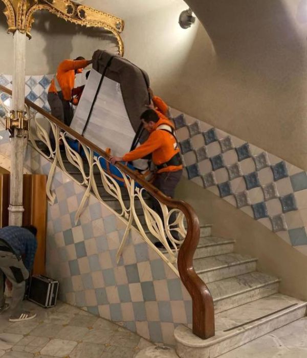 equipo subiendo piano de cola por las escaleras circulares para ser colocado en sala de musica