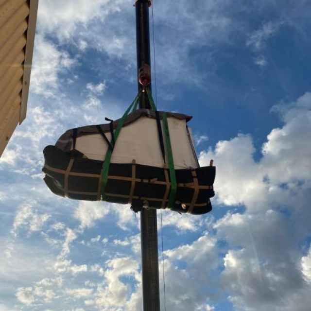 grua elevando un piano para ser instalado en un piso de alta altura
