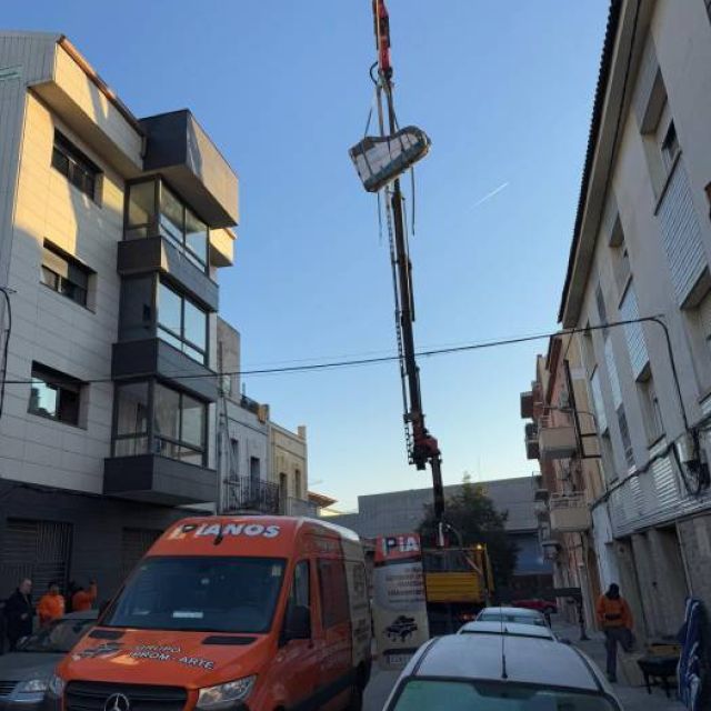 GRua elevando un piano para ser instalado en un tercer piso